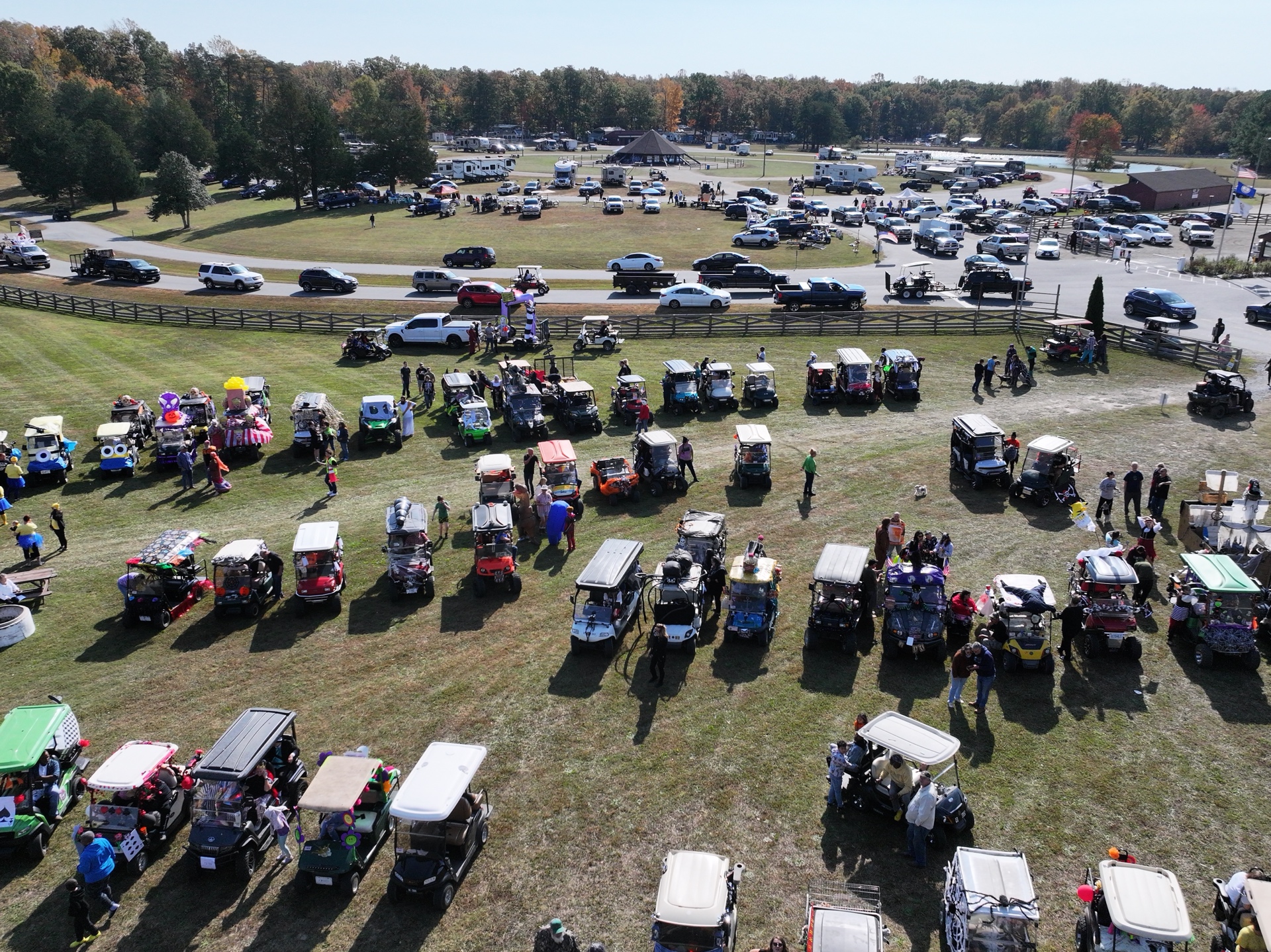 Aerial view of golf cart parade with pavilion and lake in background