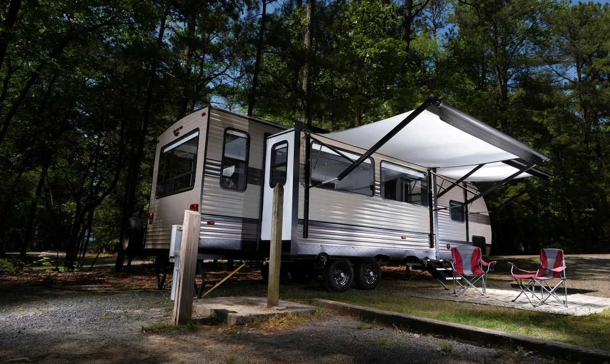Travel trailer parked on a deeded lot at Indian Acres Campground with awning extended